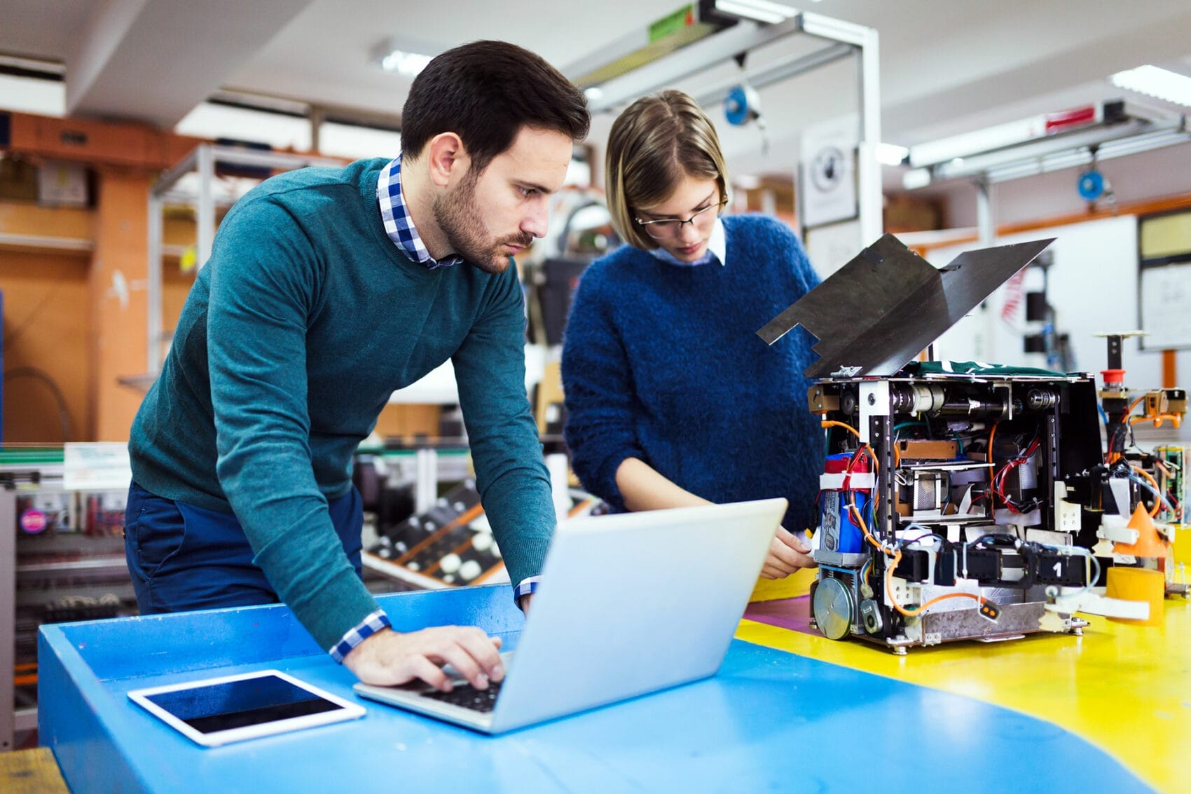 2 colleagues inspecting machinery in a workshop